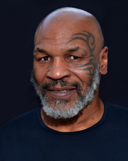 Mike Tyson poses for a picture in a black t-shirt.